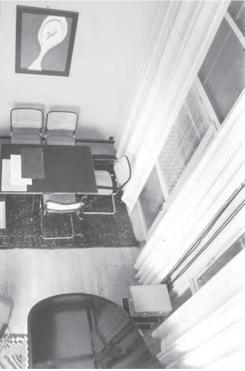 Vogelperspektive eines Raums mit Tisch und Stühlen, Vorhängen, Teppich und Wandbild, Corbusier